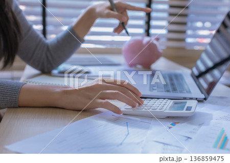 Business woman or accountant working on calculator to calculate business data in modern office. Business woman or accountant working on calculator to calculate business data in modern office. 136859475
