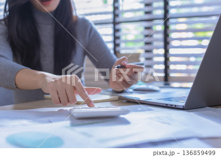 Business woman or accountant working on calculator to calculate business data in modern office. Business woman or accountant working on calculator to calculate business data in modern office. 136859499