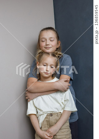 Adorable young sister and brother hugging indoor. Sibling children together portrait Adorable young sister and brother hugging indoor. Sibling children together portrait 136859545