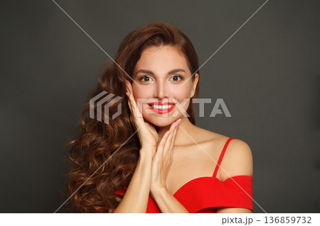 Perfect surprised woman with curly hairstyle and makeup holding her hand with her face Perfect surprised woman with curly hairstyle and makeup holding her hand with her face 136859732