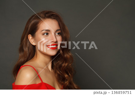 Joyful woman with long hair and make-up on black background. Gorgeous woman with curly hairstyle Joyful woman with long hair and make-up on black background. Gorgeous woman with curly hairstyle 136859751