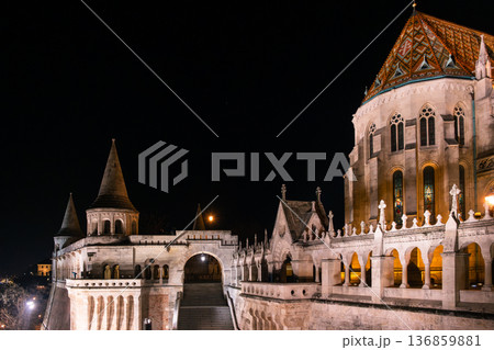 Fisherman's Bastion in Budapest illuminated at night. The historic structure features turrets and arches, surrounded by a quiet plaza. Fisherman's Bastion in Budapest illuminated at night. The historic structure features turrets and arches, surrounded by a quiet plaza. 136859881