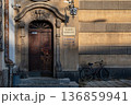 Historic building entrance with a bicycle parked nearby at sunset 136859941