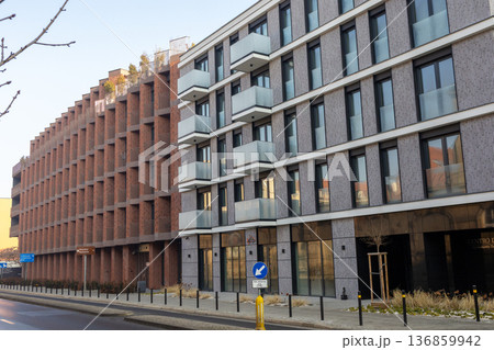 Modern buildings line a street in a city during daytime with clear skies 136859942