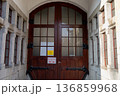 Large wooden door with glass panels in a stone building 136859968