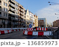 Road construction work in urban area with nearby buildings and signs 136859973