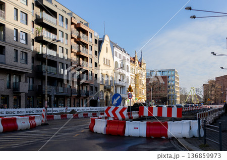 Road construction work in urban area with nearby buildings and signs 136859973