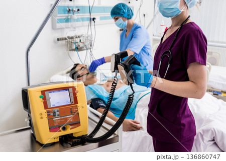 Doctors give resuscitation to a male patient in the emergency room. 136860747