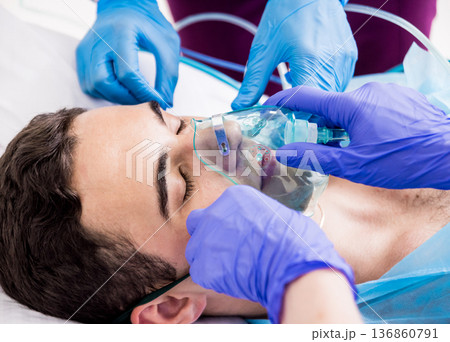 Doctors give resuscitation to a male patient in the emergency room. 136860791