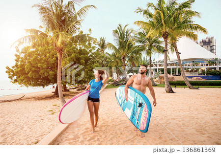 Two young surfers with boards on the beach Two young surfers with boards on the beach 136861369
