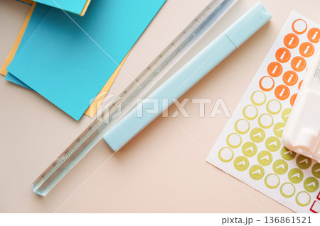 Paper trimmer with blue cardstock and sticker sheet on pastel background, minimal paper craft concept Paper trimmer with blue cardstock and sticker sheet on pastel background, minimal paper craft concept 136861521