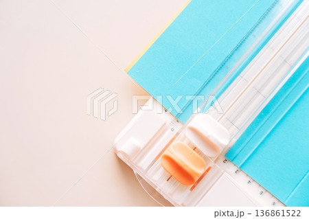 Paper cutter corner with blue cardstock and orange slider, minimal paper crafting background 136861522