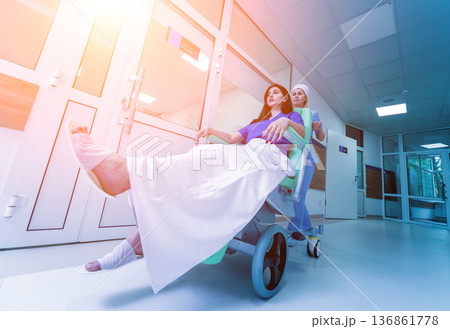 Nurse moves mobile medical chair with patient at hospital. Medical equipment. Nurse moves mobile medical chair with patient at hospital. Medical equipment. 136861778