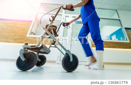 Patient on rollator with hand brakes moving in hospital Patient on rollator with hand brakes moving in hospital 136861779
