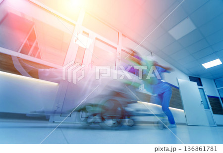 Nurse moves mobile medical chair with patient at hospital. Medical equipment. Blurred abstract background 136861781
