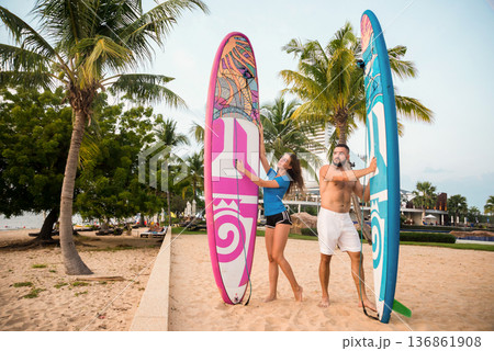 Two young surfers with boards on the beach 136861908