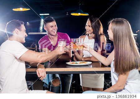 Cheerful friends in the pub. Drinking beer, talking, having fun. Cheerful friends in the pub. Drinking beer, talking, having fun. 136861934