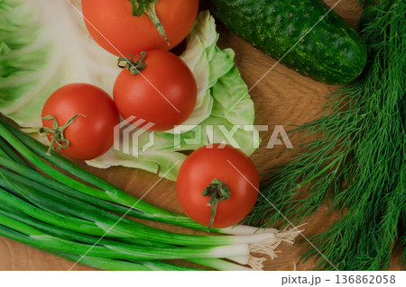 Fresh vegetables on a chopping wooden board, about to turn into a salad. Fresh vegetables on a chopping wooden board, about to turn into a salad. 136862058
