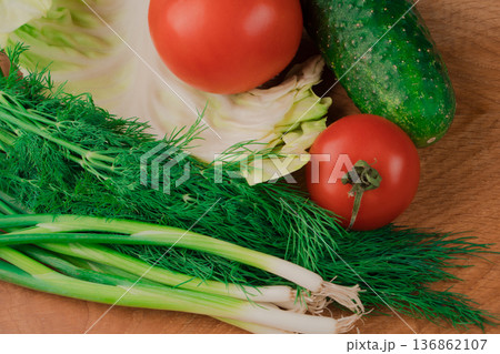 Nutrients are ideal for a delicious salad of fresh vegetables on a wooden board. Nutrients are ideal for a delicious salad of fresh vegetables on a wooden board. 136862107