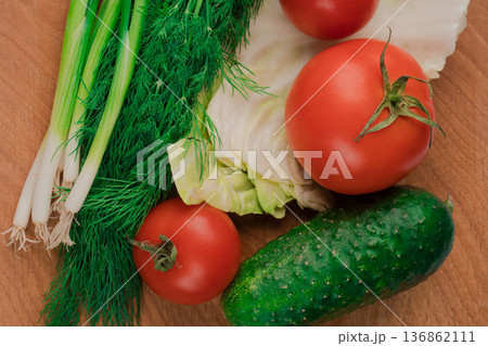 Nutrients are ideal for a delicious salad of fresh vegetables on a wooden board. Nutrients are ideal for a delicious salad of fresh vegetables on a wooden board. 136862111