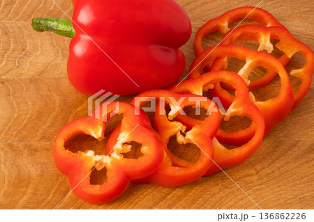 Sweet pepper whole and slices on a wooden board Sweet pepper whole and slices on a wooden board 136862226