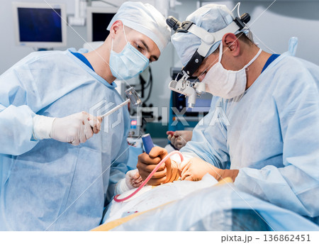 Spinal surgery. Group of surgeons in operating room with surgery equipment.  136862451