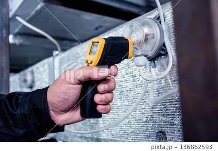 Technician use infrared thermal imaging camera to check temperature at fuse-box 136862593