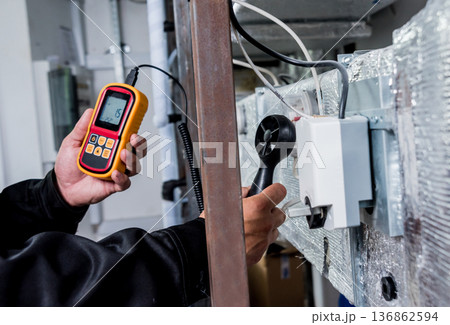 Technician use hand-held anemometer measuring air flowing measurement 136862594