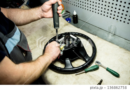 Car mechanic repair steering wheel at service station. Car repair service 136862758