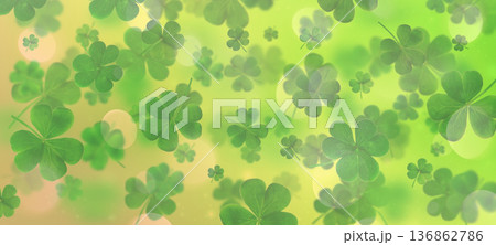 Scattered clover leaves on a blurred green gradient background with light bokeh. St. Patrick's Day 136862786