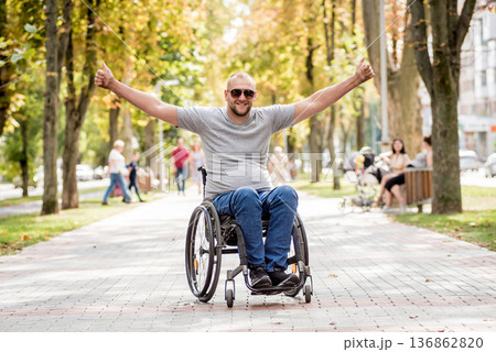 Handicapped man in wheelchair walk at the park alley Handicapped man in wheelchair walk at the park alley 136862820