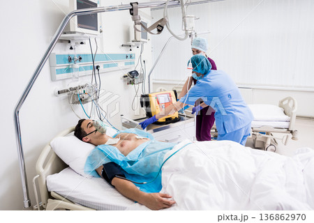 Doctors give resuscitation to a male patient in the emergency room. 136862970