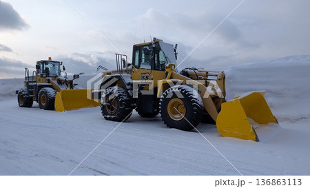 冬の港で作業する除雪車 雪を押すホイールローダーと重機 136863113
