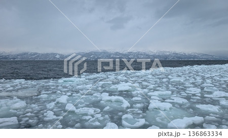 北海道の流氷原とオホーツク海 雪山が連なる冬の海景 北海道の流氷原とオホーツク海 雪山が連なる冬の海景 136863334