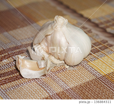 garlic in the husk on the background of the tablecloth garlic in the husk on the background of the tablecloth 136864311