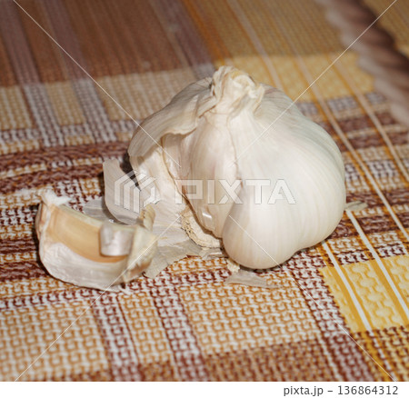 garlic in the husk on the background of the tablecloth 136864312