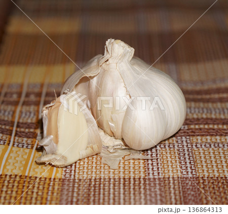 garlic in the husk on the background of the tablecloth 136864313