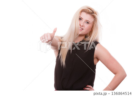 Smiling blonde woman making thumb up gesture 136864514