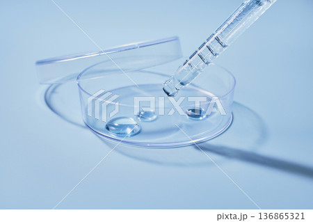 Cosmetic serum drop from pipette into petri dish, skincare laboratory research 136865321