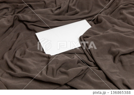 Neutral mocha textile mockup with blank envelope. 136865388