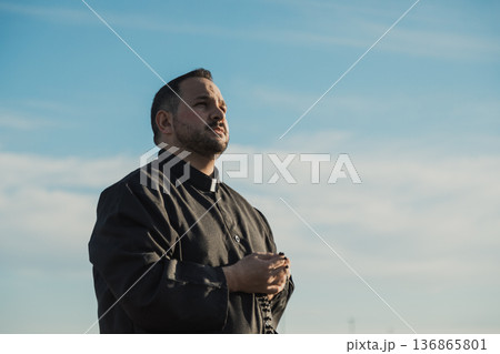 Spiritual Priest Looking At God In The Sky  136865801