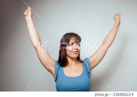 Woman Celebrating Victory with Raised Arms 136866224