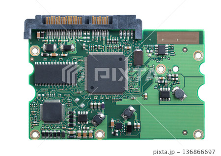 Printed circuit board, PCB of a hard disk drive, HDD, from above. Flat piece of layered fiberglass with copper traces, memory, and and support chips, to be mounted to the exterior of the device. Photo 136866697