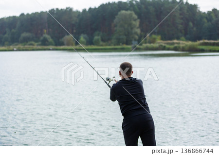 Man fishing from wooden lake pier Man fishing from wooden lake pier 136866744