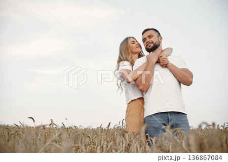 Cute couple in a field. Lady in a white blouse. Guy in a white shirt Cute couple in a field. Lady in a white blouse. Guy in a white shirt 136867084