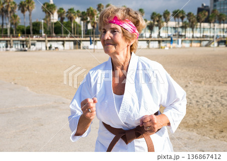 Mature woman running on beach Mature woman running on beach 136867412
