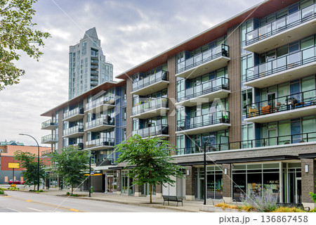 Low-rise and high-rise residential buildings with shops and offices along the street 136867458