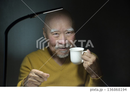 ホットドリンクを飲んでくつろぐ老人 136868194