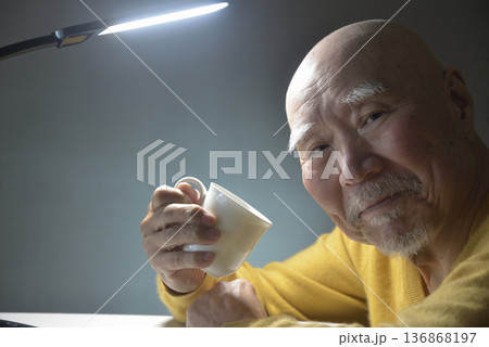 ホットドリンクを飲んでくつろぐ老人 136868197