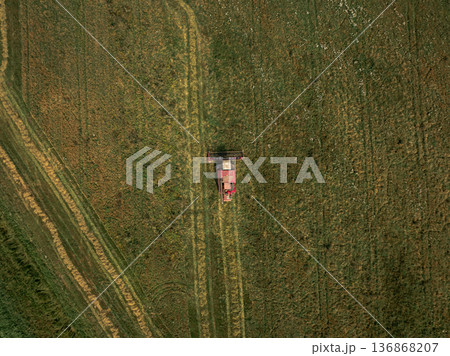 Aerial View of Green Field with Red Harvester in Belarus Aerial View of Green Field with Red Harvester in Belarus 136868207
